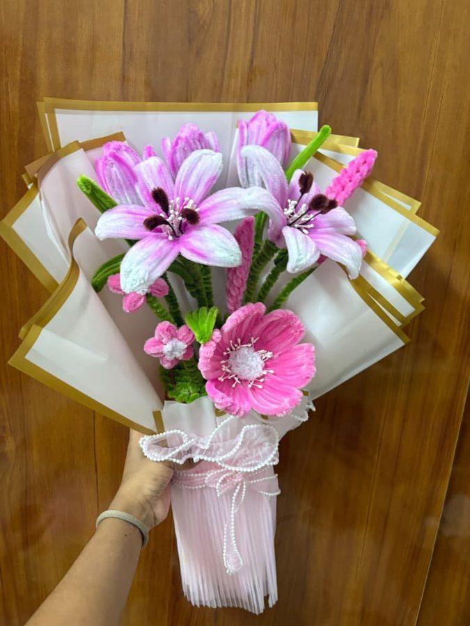 Pink Lily Bouquet. Handcrafted flower bouquet made from soft chenille wire, with pink lilies, a large pink bloom, tulips, and green leaves. Wrapped in cream-and-gold paper with a pearl-beaded ribbon. A grand gift for…